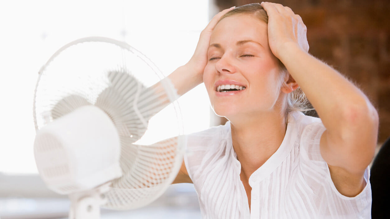 woman cooling herself with a fan